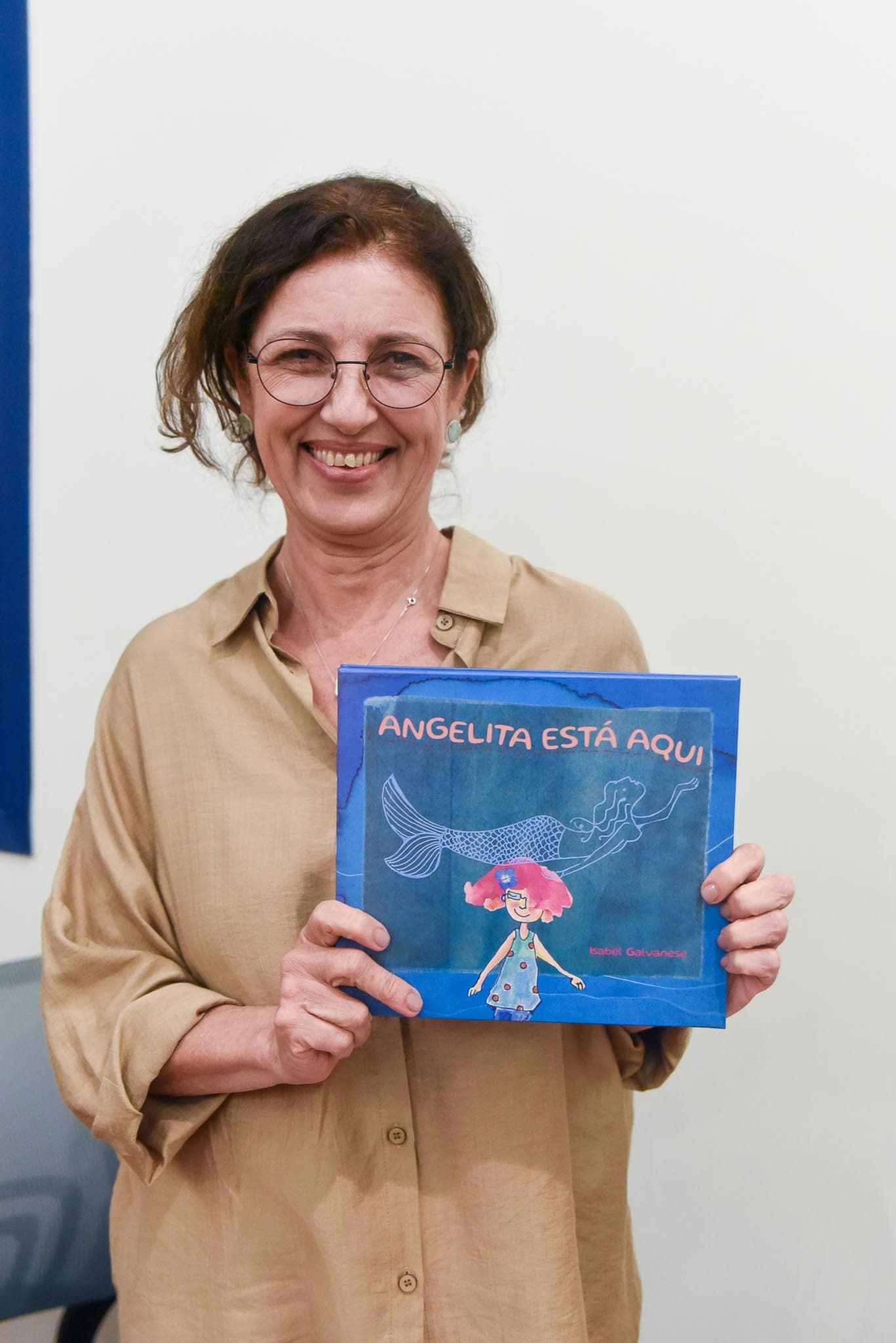 Autora com o livro Angelita Está Aqui