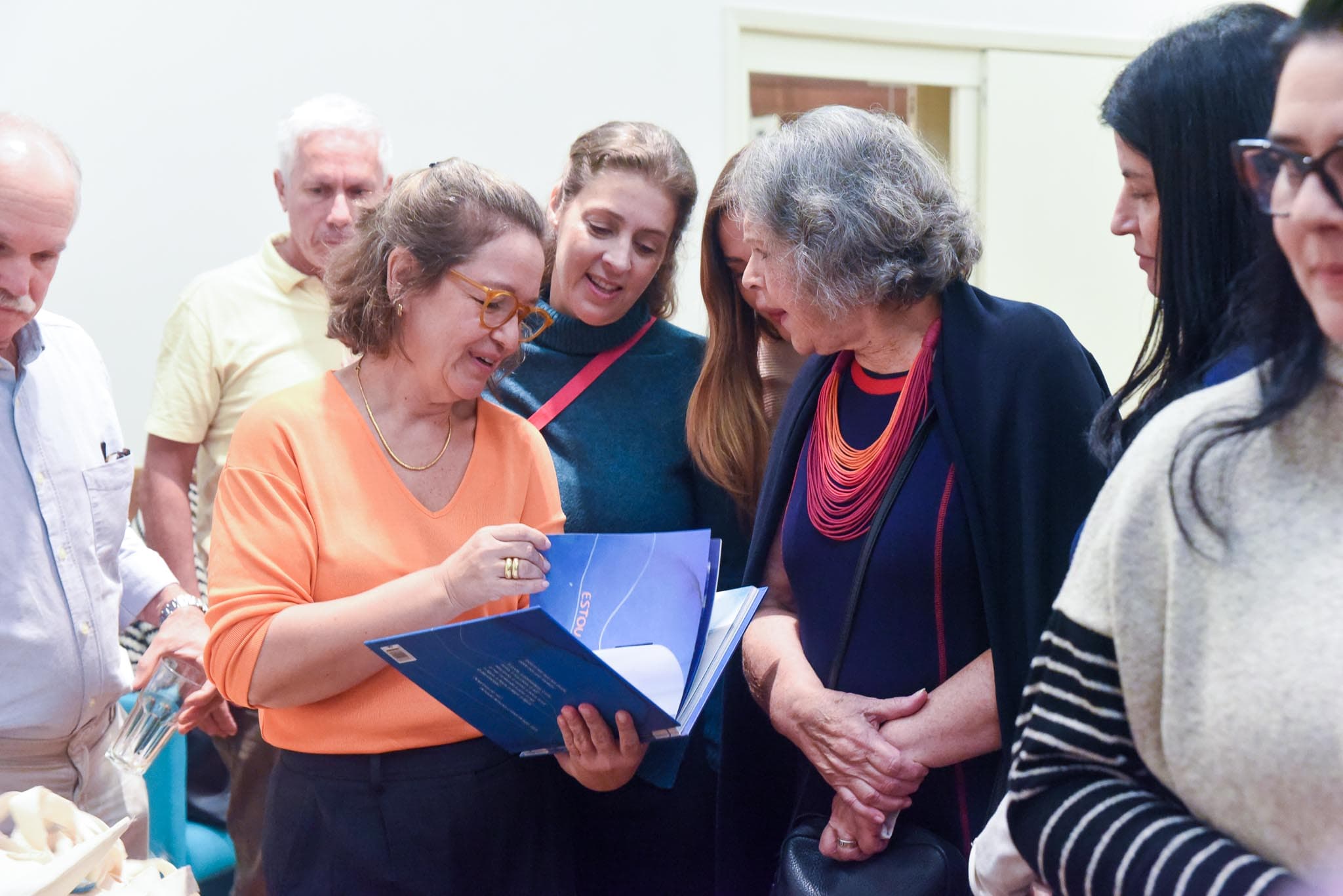 Convidados folheando o livro no lançamento